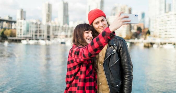 Couple taking selfie next to a harbour