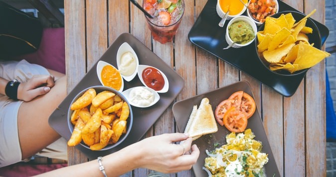 Plates of tapas food on an outdoor wood table