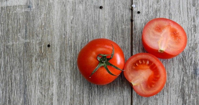 Whole and Sliced Tomatoes on an aged wood surface